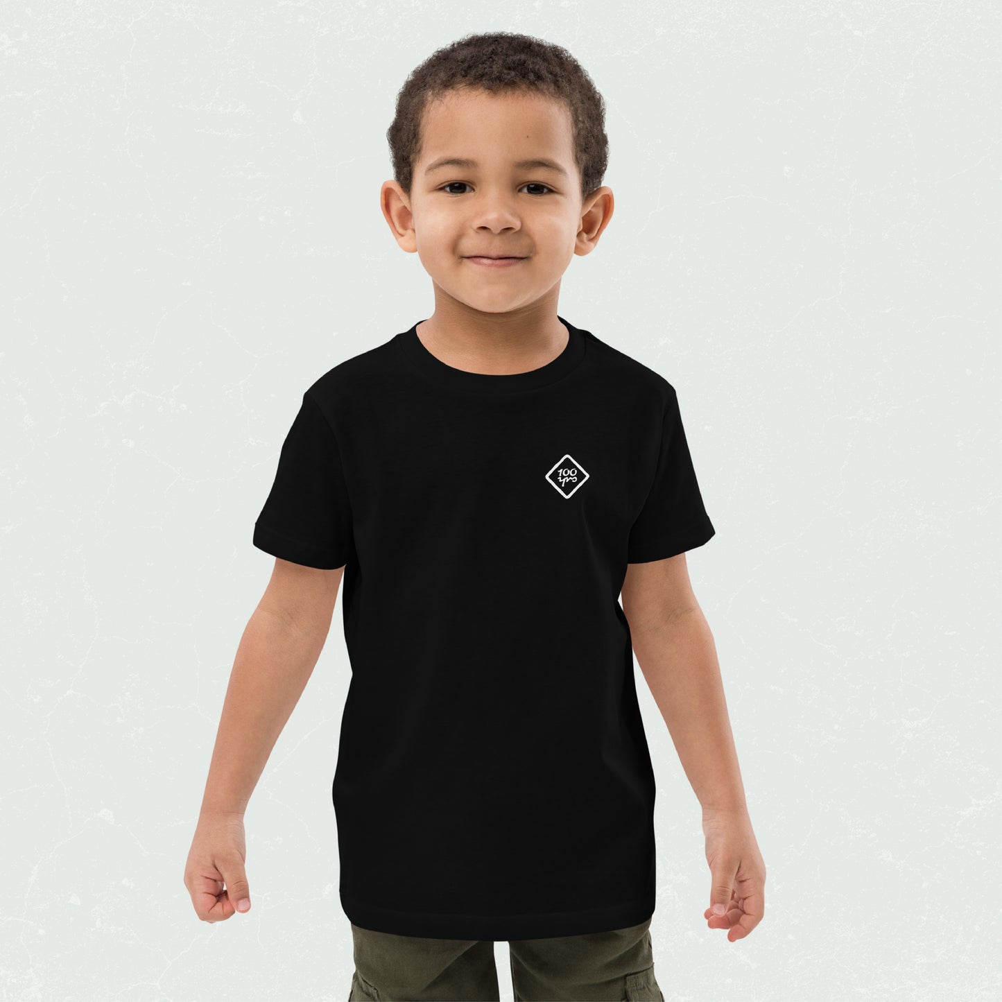 Young boy wearing a black unisex organic kids t-shirt with the "100yrs" logo.